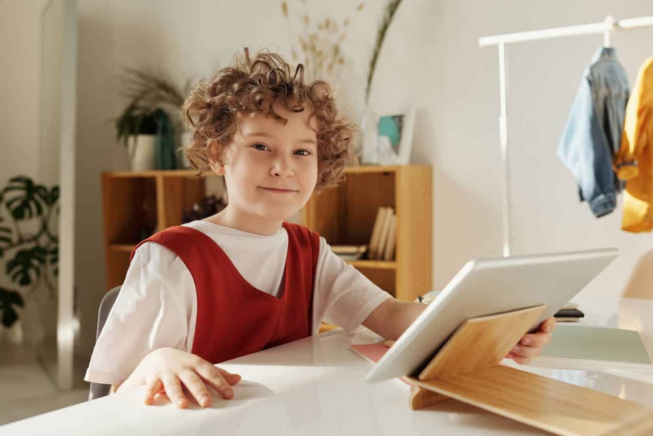 Petit garçon faisant ses devoirs sur sa tablette grâce à des logiciels adaptés à la dyslexie